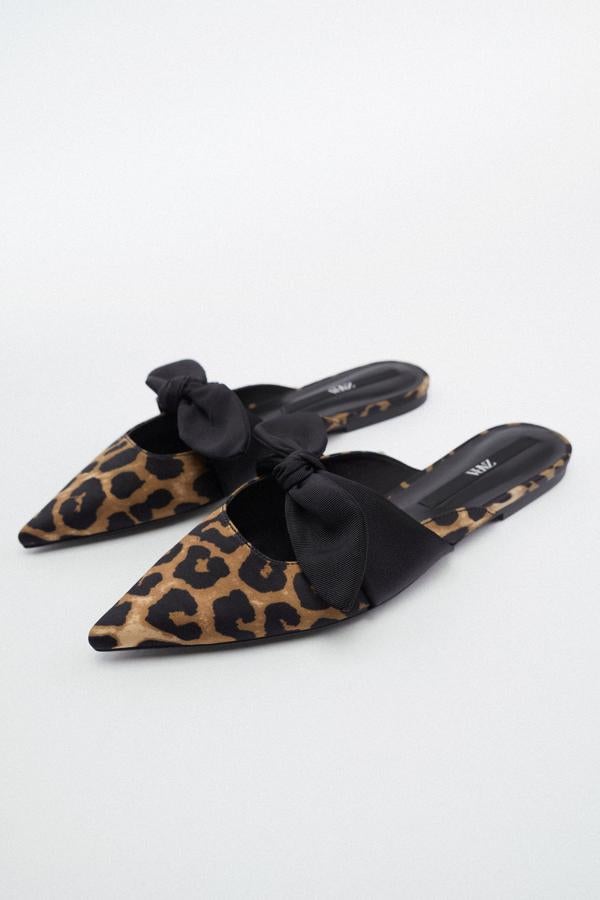 Estos mules de Zara tienen un print de leopardo con un lazo negro que los remata, aportándole un toque diferente. Además, tiene un acabado en punta, siendo una de las características que más buscan las expertas en moda. Precio: 22,95 €. 