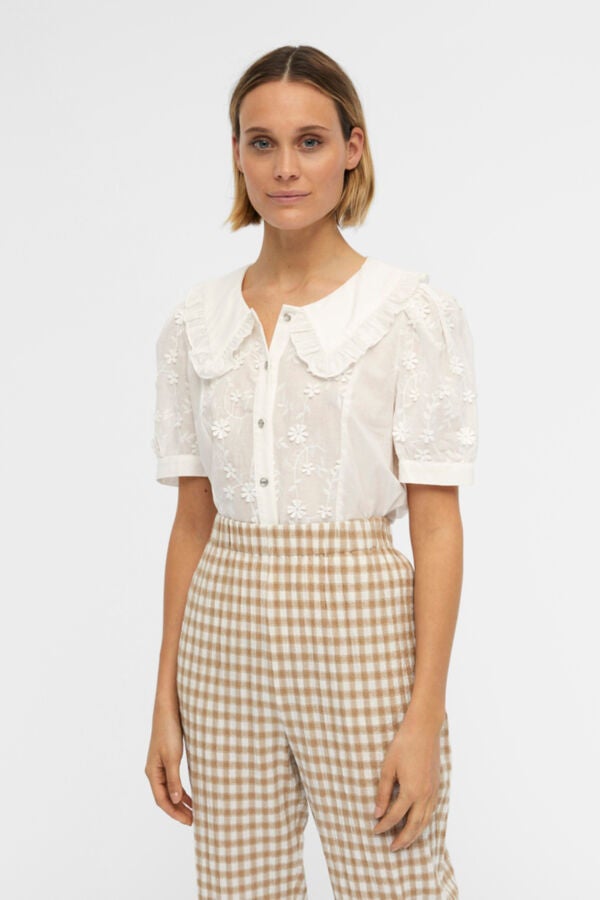 Un básico que no puede faltar en cualquier armario es una camisa blanca. Los cuellos baby doll son muy franceses, y con la llegada del buen tiempo, esta camisa de Slow Love (39,99€) bordada nos ha parecido una gran opción para combinar con todo tipo de prendas: pantalones, faldas… Las opciones son infinitas. 