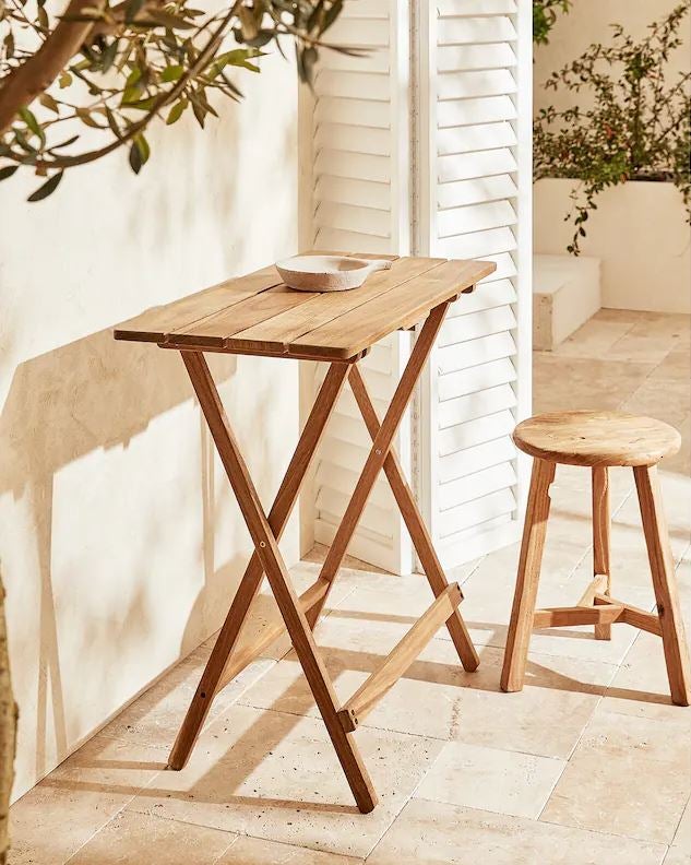 Perfecta para terrazas pequeñas o como mueble auxiliar, esta mesa plegable en madera de acacia es una pieza imprescindible, funcional y versátil para espacios exteriores. Cuesta 149 euros en Zara Home.