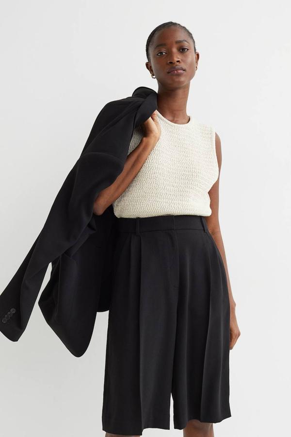 Bermudas de traje con tejido ligero y fluido, corte holgado, talle alto, detalles de pinzas y raya marcada, trabillas para cinturón y bolsillos al bies, color negro, de H&M. Cuestan 19,99 euros.