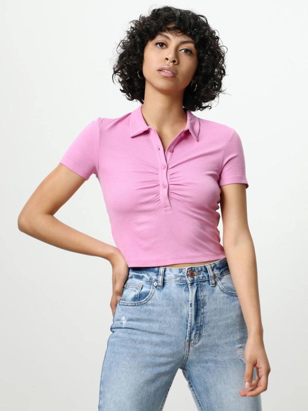 Camiseta tipo polo de canalé con cuello solapa, botonadura fruncida, manga corta y silueta ajustada. Está disponible en amarillo, rosa y blanco, por 7,99 euros.