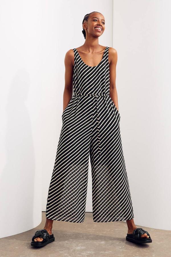 Mono largo en gasa de corte relajado con tirantes anchos, escote redondo, pernera holgada y cinturón de lazada, con estampado a rayas en negro y blanco, de H&M. Su precio es de 39,99 euros.