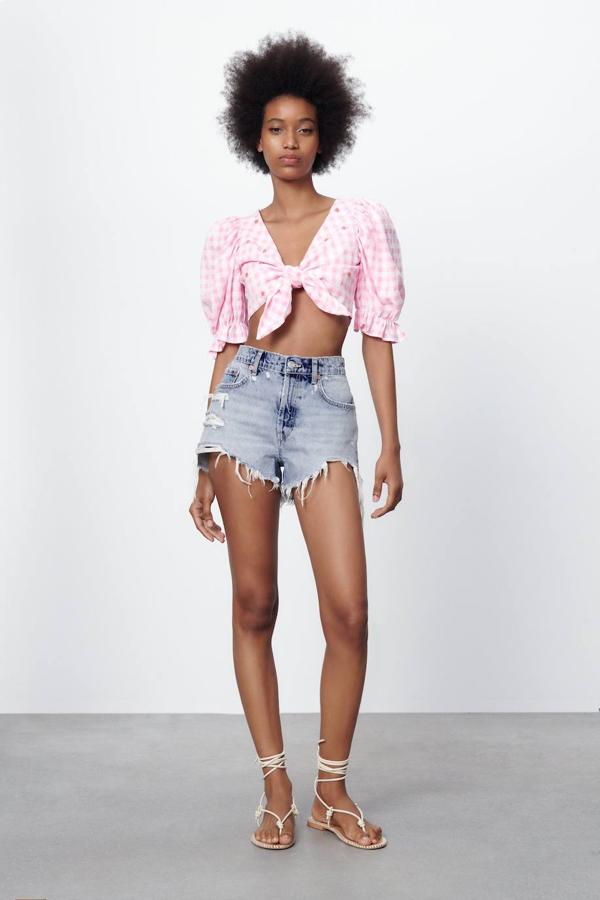 Cuerpo cropped en estampado de vichy blanco y rosa, con escote de pico, detalle de lazada frontal, manga corta abullonada con elástico y terminada en volante, más detalle de abalorios en forma de flor, de Zara. Lo encontrarás a 25,95 euros.