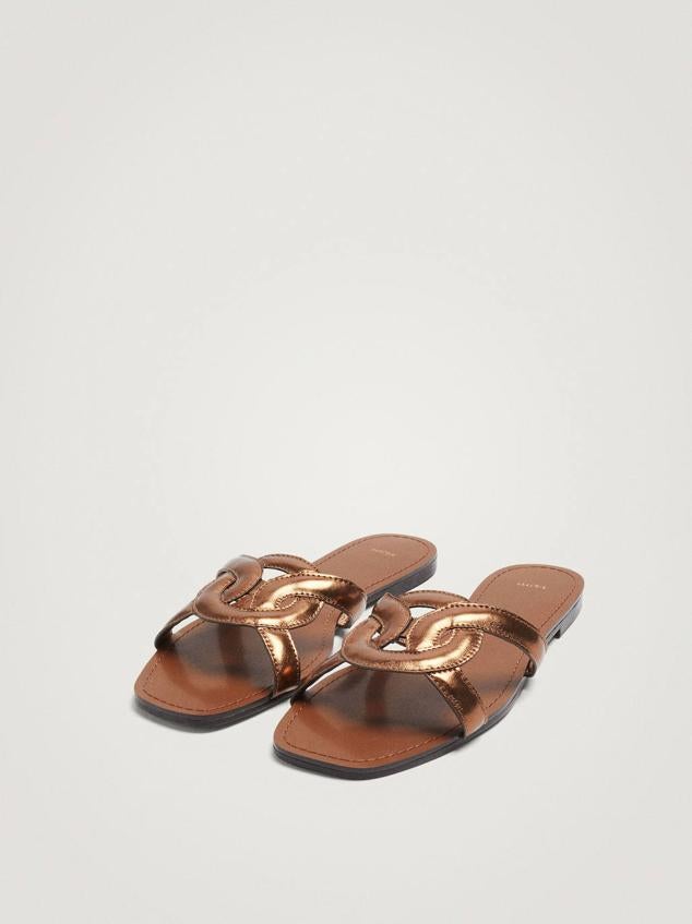 Sandalia plana destalonada con detalle de tiras cruzadas en acabado efecto piel metalizado, color dorado, de Parfois. Cuestan 19,99 euros.