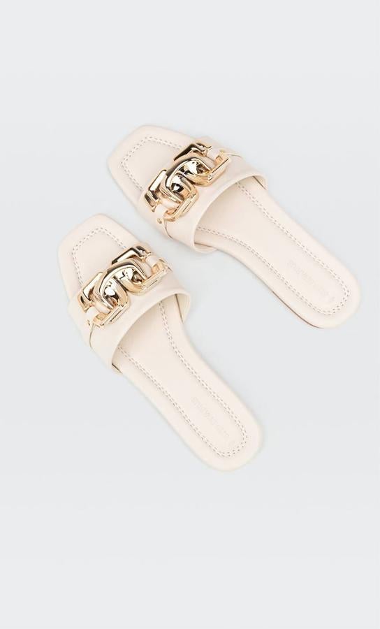 Sandalia plana destalonada en tejido efecto piel con tira ancha delantera decorada con hebilla dorada, en crudo o negro, de Stradivarius. Tiene un precio de 25,99 euros.