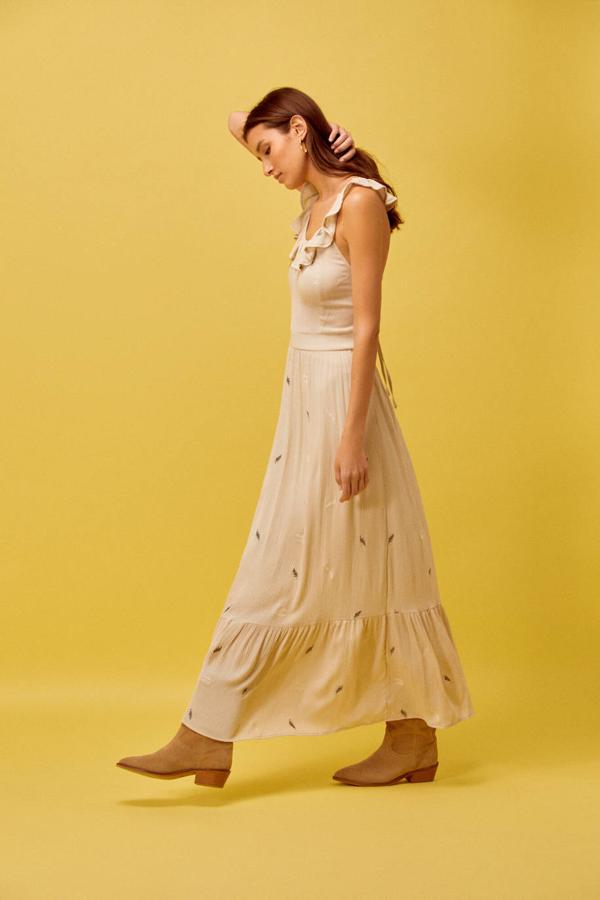 Vestido en tejido ligero color amarillo claro y bordado de plumas, escote redondo con tirantes de volantes cruzados en la espalda abierta y falda amplia con bajo acabado en volante, de Cortefiel. Puedes comprarlo por 59,99 euros.
