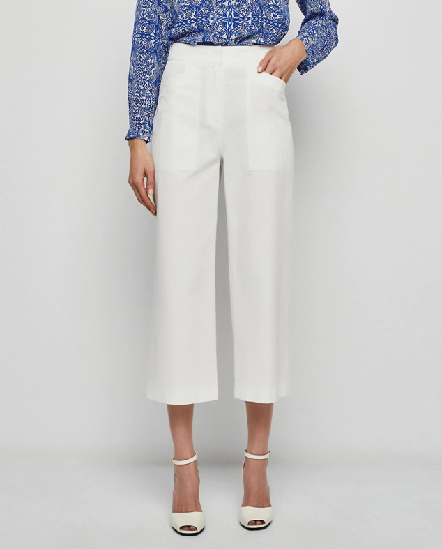 Pantalón blanco recto con un favorecedor tiro alto con dos maxi bolsillos frontales que le aportan un detalle diferente. Son de Mirto y puedes comprarlos en El Corte Inglés. Precio: 175 €.