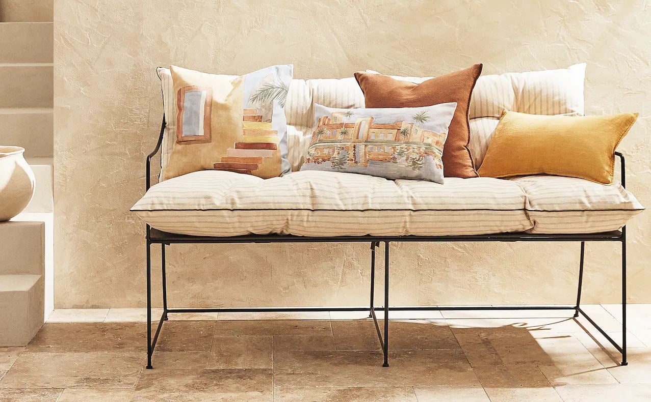Además del maravilloso banco de forja, estas rebajas de verano no podremos (ni querremos) resistirnos a los increíbles cojines pintados de Zara Home, disponibles desde 12.99 euros.