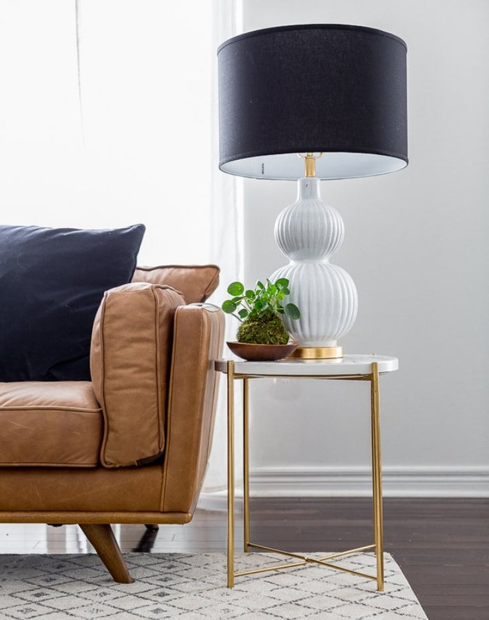 Parece una mesa auxiliar de lujo sacada de un anticuario y se convertirá en la protagonista de los salones más elegantes. Pero en realidad esta mesita es la GLADOM de IKEA, solo que sus patas se han pintado en color dorado y la superficie se ha forrado con vinilo efecto mármol.