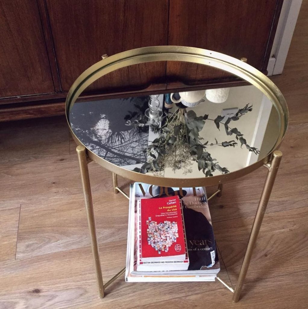 En este caso, más allá del spray dorado que utilizaremos en la estructura, cambiamos la bandeja original de la mesa GLADOM de IKEA por una superficie de espejo (hay láminas adhesivas muy baratas y fáciles de colocar sobre la propia base) y conseguimos un acabado muy sofisticado.