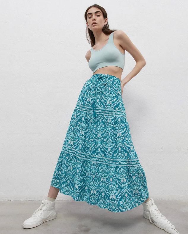 Falda larga estampada en verde y blanco con talle alto, cintura elástica ajustable mediante cordones terminados en pompones y corte amplio con vuelo, de Sfera. La encontrarás a 25,99 euros.