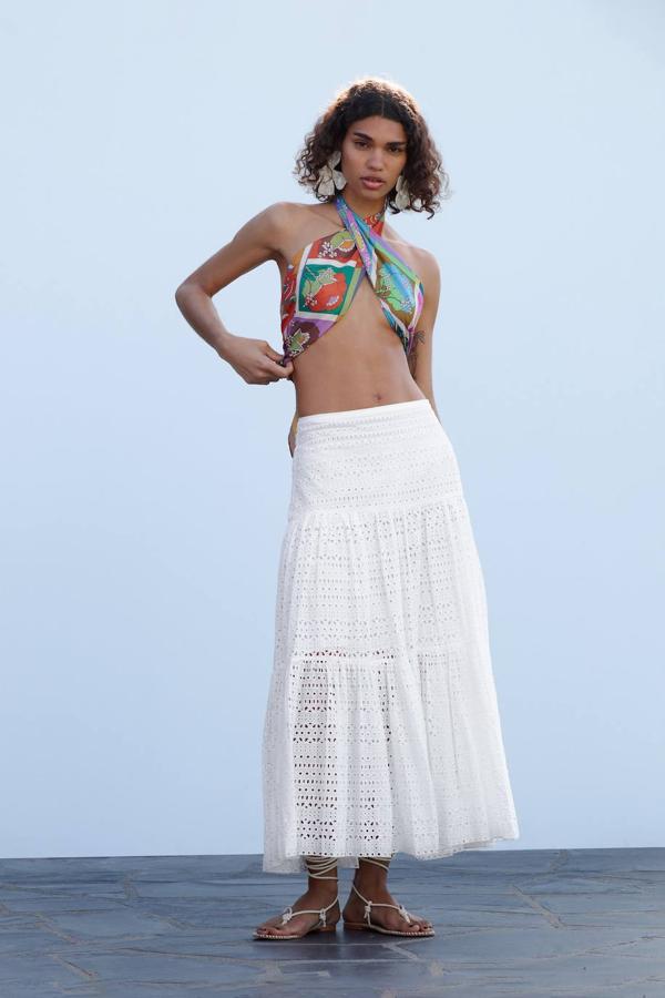 Maxi falda en tejido ligero con bordados y perforados, talle alto con cintura elástica y falda amplia con vuelo terminada en volante, color blanco, de Zara. Puedes comprarla actualmente por solo 25,99 euros.