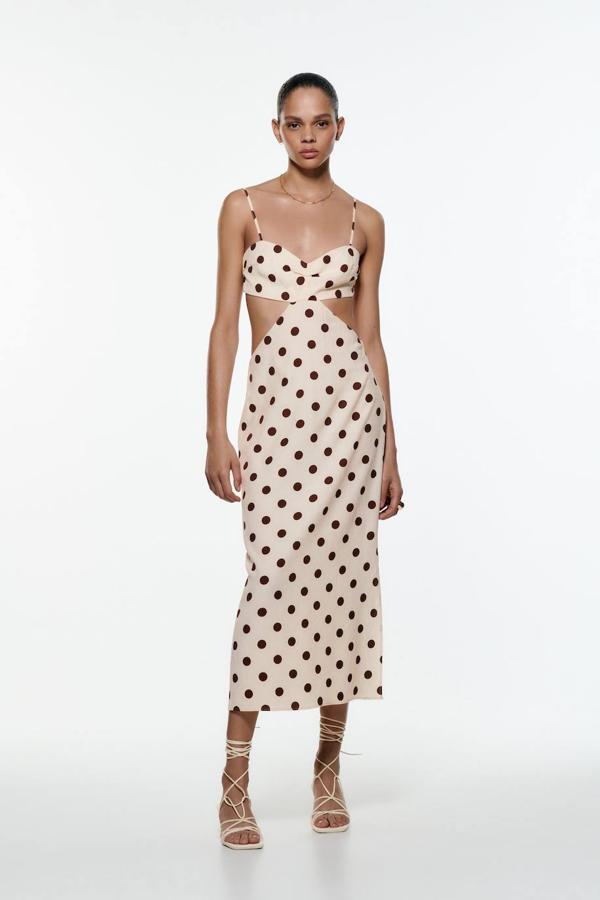 Vestido midi estampado de lunares en crudo y marrón. Es un diseño de escote recto tirantes, aberturas en los laterales de la cintura y falda recta. Puedes encontrarlo en Zara con una rebaja a 25,99 euros.
