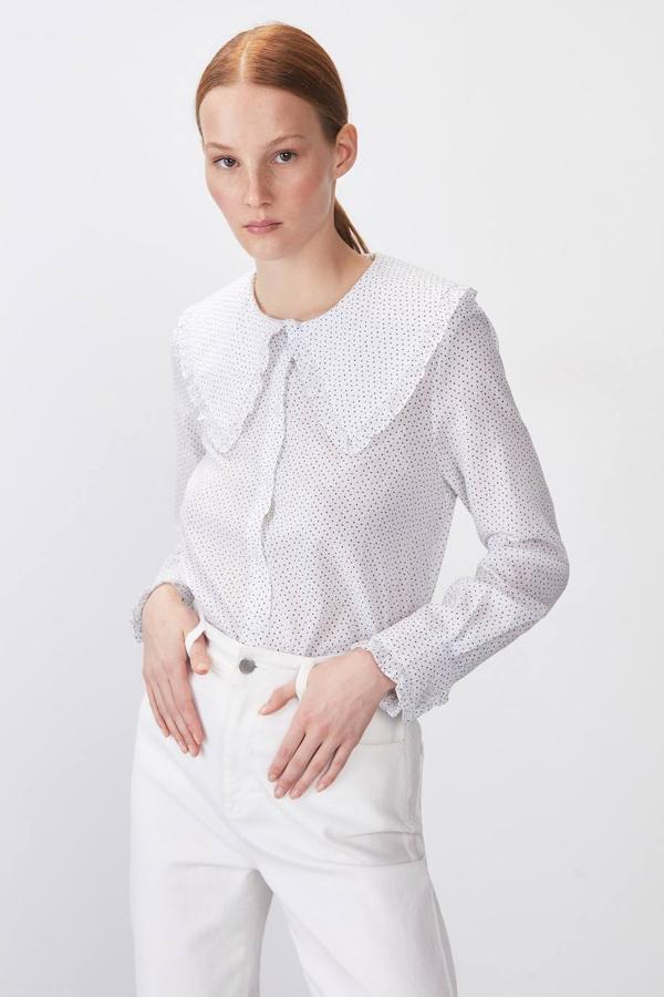 Camisa 100% algodón con manga larga terminada en puño, cuello bobo, acabados de volantes y mini estampado, en blanco y azul. Ahora cuesta 7,99 euros.