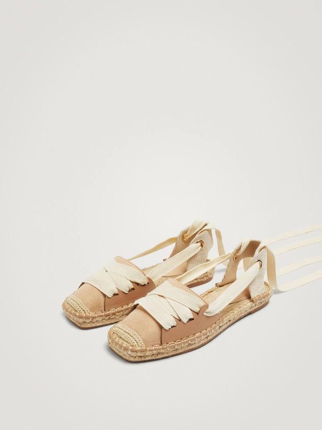Alpargatas planas con suela de yute y detalles de lazadas para anudas, en tonos crudo y rosa. Tienen un precio de 29,99 euros.