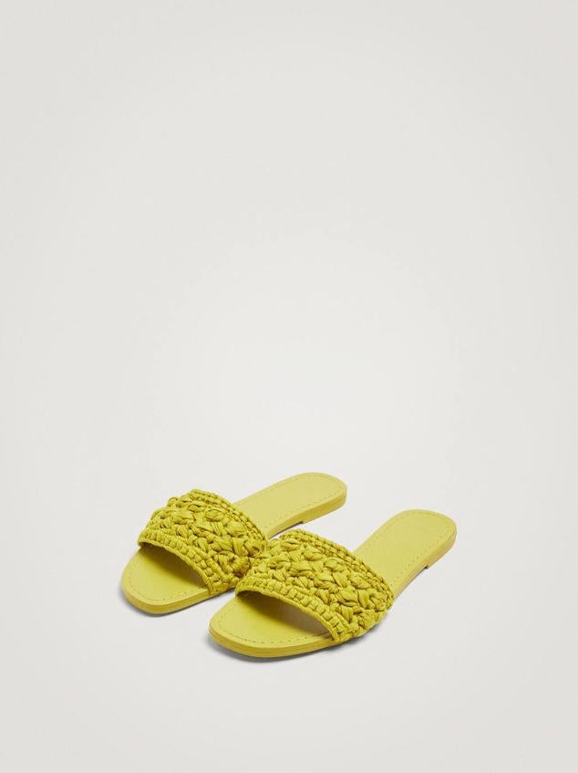 Sandalia plana destalonada con tira delantera en crochet color amarillo. Su coste es de 25,99 euros.