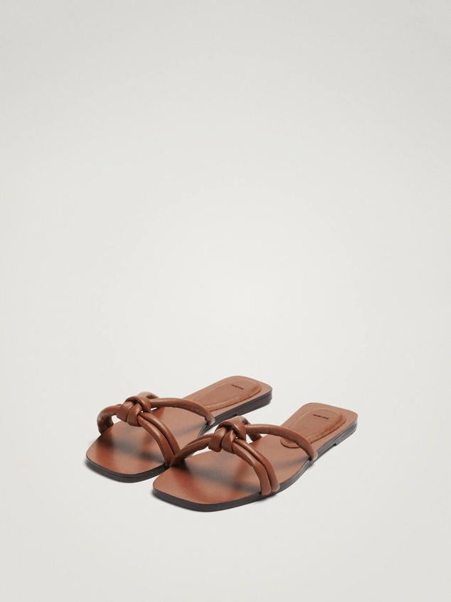 Sandalia plana destalonada en tejido de piel con tiras anudadas en la parte delantera, color marrón. Cuestan 25,99 euros, con descuento.