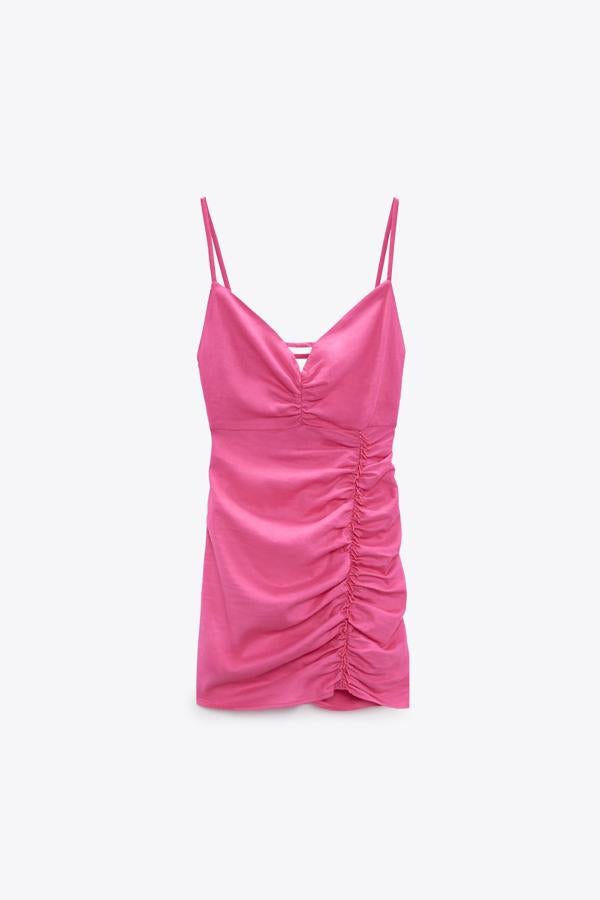 Vestido mini confeccionado con tejido en mezcla de lino. Escote pico y tirantes finos con lazada en la espalda. Detalle de frunces y aplicación de abalorios delanteros. De Zara. Precio: 29,95 €. 