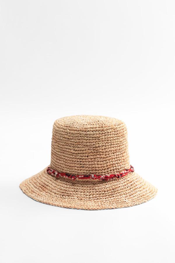 Un sombrero de rafia que parece que no tiene nada especial, pero que realmente no es como los demás Su ala corta y la tira roja estampada con flores marcan la diferencia. Sombrero de rafia de Zara (25,99 euros)
