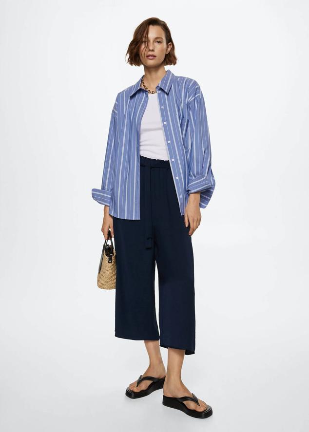 Pantalón culotte fluido con elástico fruncido en la cintura, tiro alto y cinturón de lazada a juego, color azul marino, de Mango. Los encontrarás con descuento a 19,99 euros.