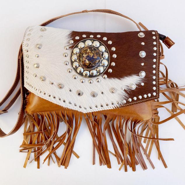 Hechos directamente en Marruecos, de cuero y pelo de potro y realizada por manos artesanas. Son espectaculares, con flecos que dan mucho movimiento al bolso y tachas con doble compartimento en su interior. Es de Lola Mara. Precio: 69,90 €.