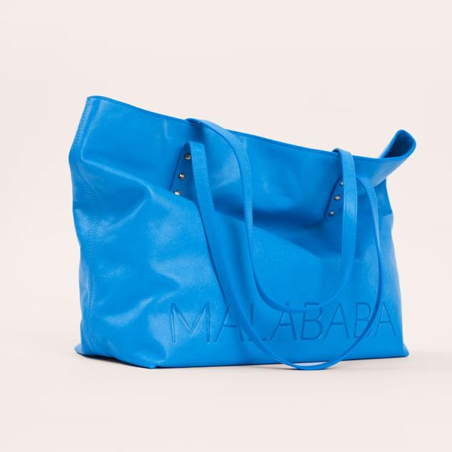 Estilo shopping y hecho con piel vacuna. Tiene el logo grabado en la piel, con asa de hombro y cierre corchetes. También tiene bolsillo interior con cremallera y destaca por ser muy ligero. Es de Malababa. Precio rebajado: 189 €.