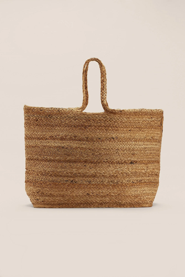 De gran tamaño, este bolso marrón tiene materiales de cordel, un diseño cuadrado y un material de yute. También tiene dos asas cortas para poder llevarlo al hombro sin problemas. Es de NA-KD. Precio rebajado: 31,97 €.