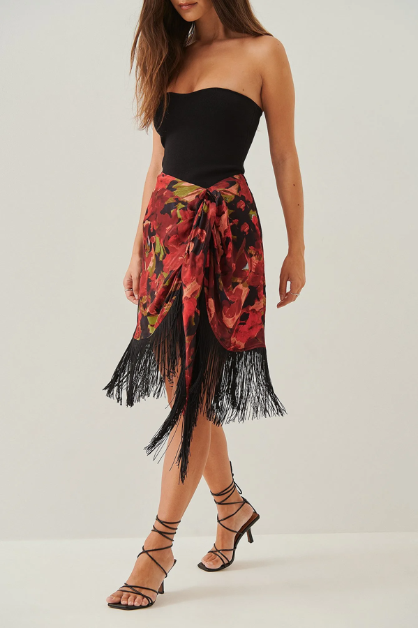 Falda corta, con cremallera lateral y detalles de flecos en el dobladillo. A destacar el detalle con nudo de corbata, el material de raso y que es multicolor. Es de NA-KD. Precio rebajado: 36,36 €.