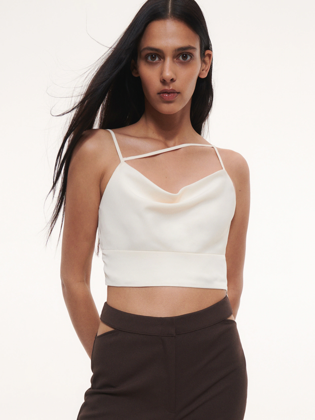 Top ajustado confeccionado en tejido con acabado satinado, con tirantes finos, cierre con cremallera lateral y cintura recortada. Es de Reserved. Precio: 19,99 €.