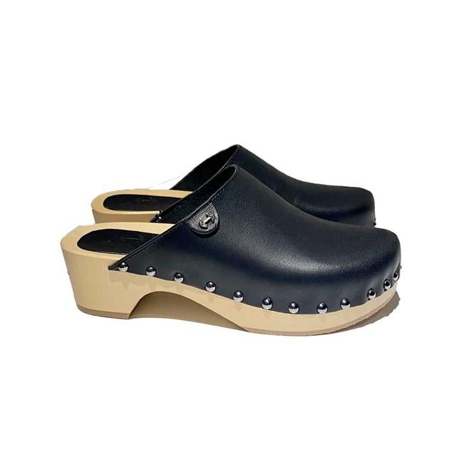 Zueco con diseño destalonado de piel en color negro. Decorado con apliques dorados como remate. Con plataforma y tacón de madera con suela de goma para mayor comodidad. Es de Ferent. Precio rebajado: 117,60 €. 