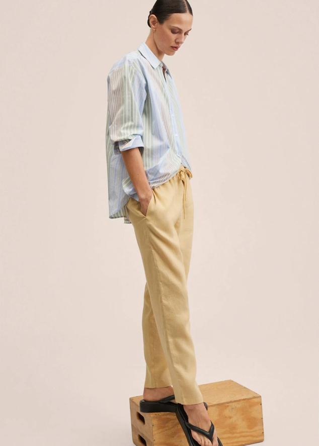 Pantalón jogger confeccionado en tejido 100% de lino con tiro medio, diseño de pernera cropped, cintura elástica ajustable mediante cordones y bolsillos, de Mango. Lo encontrarás con descuento a 22,99 euros, en cinco tonos.