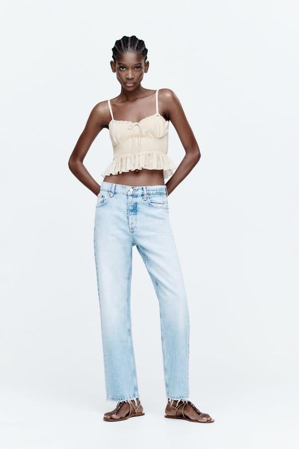 Los tops de punto se han convertido en la prenda estrella para llevar con vaqueros rectos. Top en color crudo de Zara (19,99 euros) 