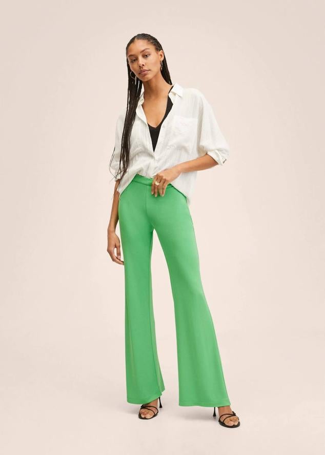 Pantalón flare largo en tejido fluido, ligero y elástico, con bajo acampanado y tiro medio, color verde, Mango. Puedes encontrarlo en rebajas a 15,99 euros.