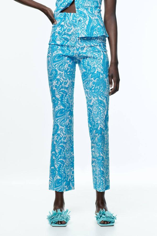 Pantalón en tejido de lino tipo flare, con tiro alto, cuatro bolsillos y estampado paisley en turquesa y blanco, de Zara. Lo comprarás con descuento por 12,99 euros.