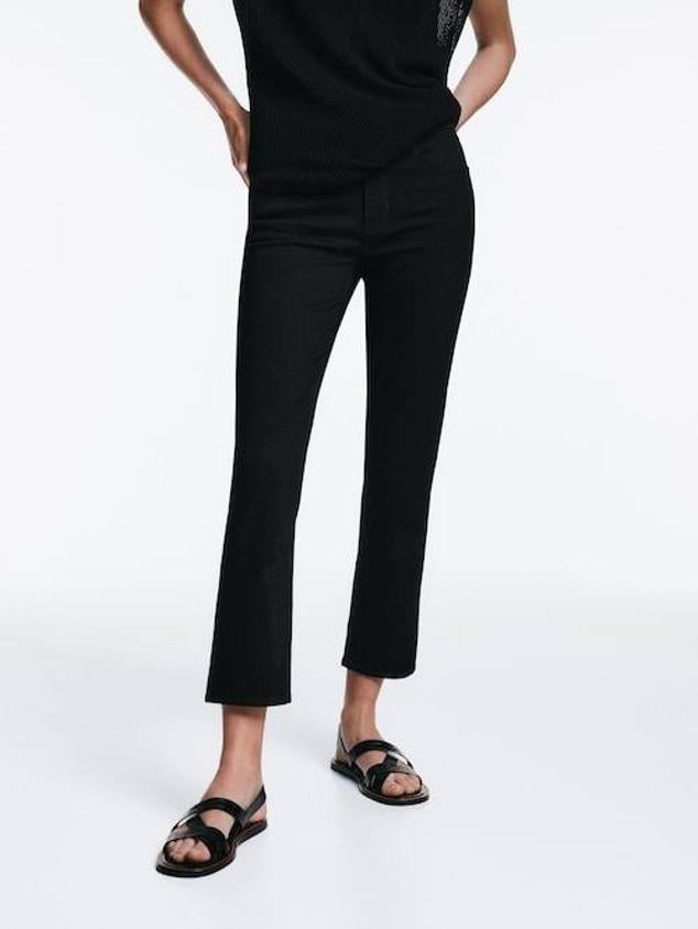 Este modelo en color negro tiene un diseño cropped y de corte slim que se ajusta a la silueta.