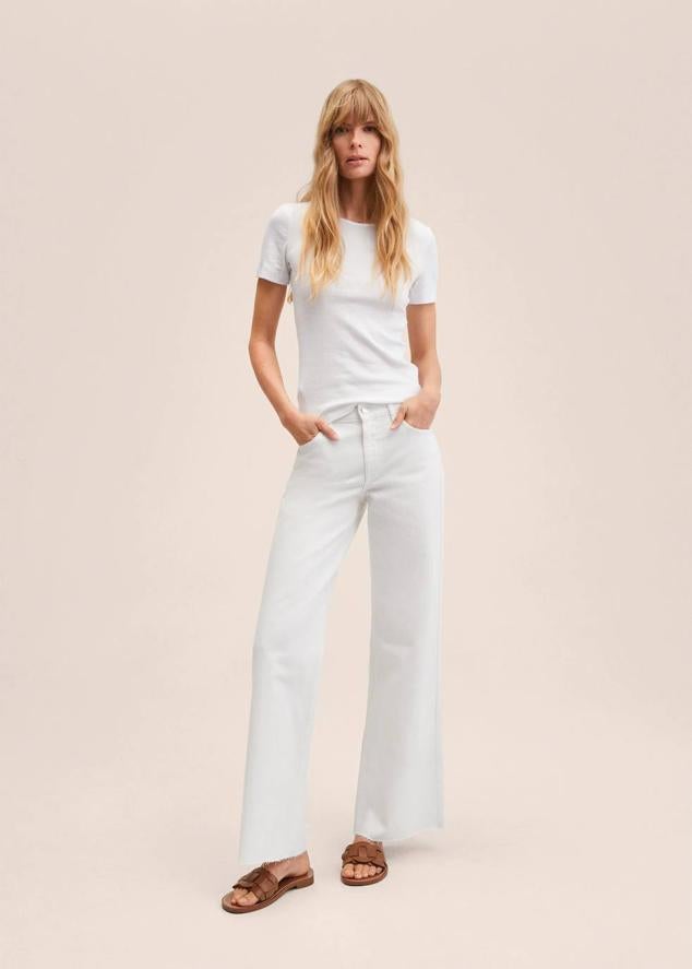 Pantalón vaquero wide leg de tiro medio y bajo sin rematar, en blanco, de Mango. Tiene un coste de 15,99 euros.