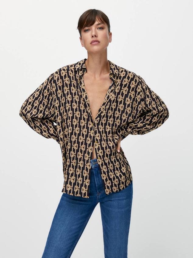 Camisa fluida de manga larga con costura de hombros caída, cuello solapa, cierre de botones y estampado de cadenas, color negro. Está disponible rebajada a 19,95 euros.