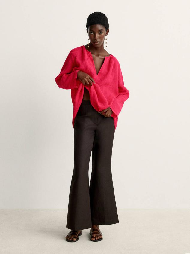 Camisa de lino con acabado gofrado, cuello redondo con escote de pico, corte amplio y manga larga, color fucsia. Puedes comprarla rebajada por 25,95 euros.