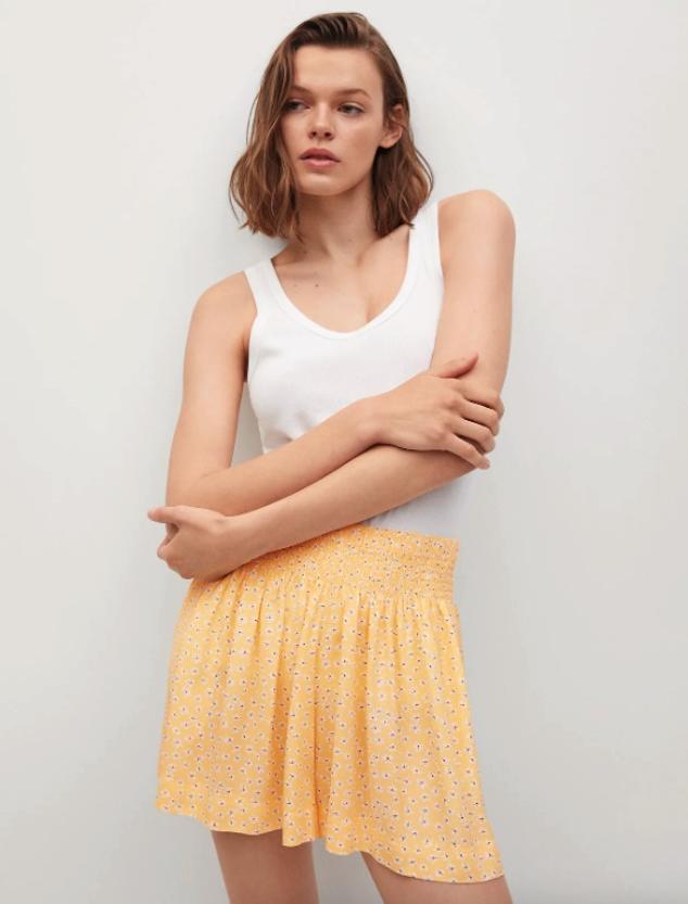 Fondo amarillo y estampado de flores blanco y negro para este pantalón corto de diseño recto con cintura elástica y perneras holgadas que tienen dos bolsillos laterales y cuestan 5,99 euros. Podemos encontrarlos entre las tallas XS y XL. 