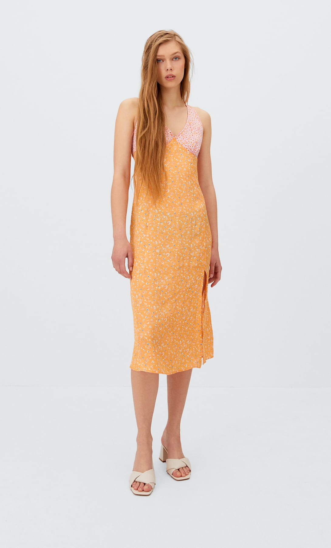 Vestido midi con diseño recto y estampado de flores. Cuenta con un escote halter y abertura en una zona lateral del vestido. Precio: 9,99 euros (antes, 29,99 euros).