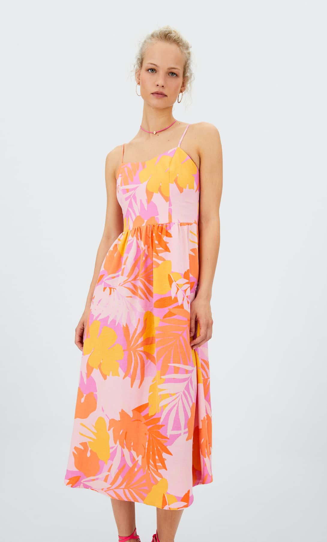 Vestido con estampado tropical multicolor con tirantes finos y escote corazón. Tiene un acabado muy fluido, ligero y cuenta con pliegues en la zona de la cintura. Precio:15,99 euros (29,99 euros).