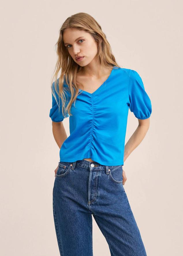Camiseta de algodón con manga corta abullonada, escote de pico y detalle fruncido, de Mango. Está rebajada a 5,99 euros.