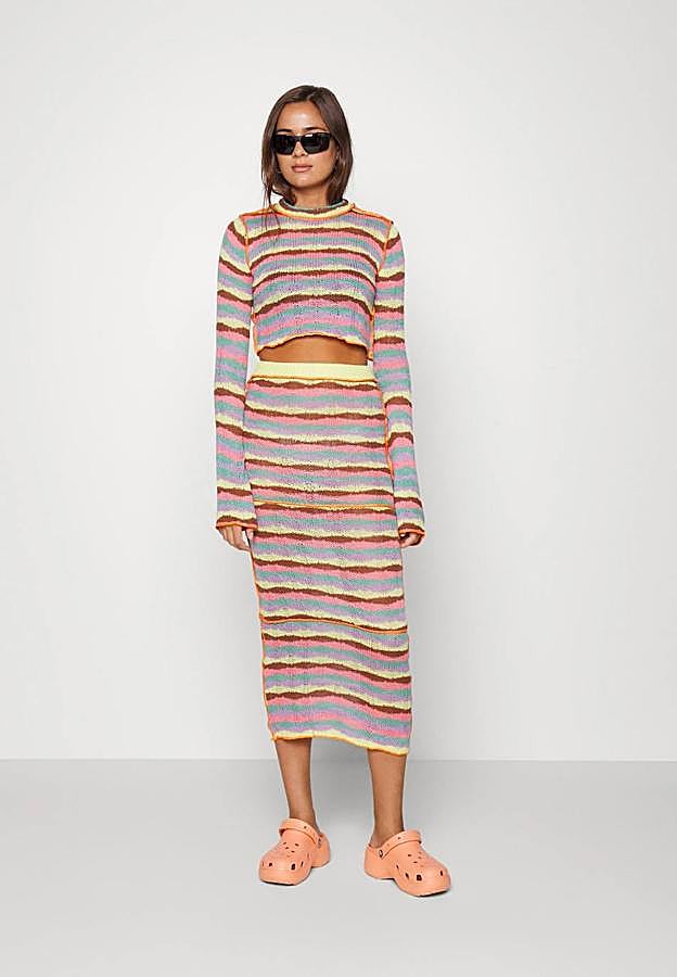 Falda midi de tubo en tejido de punto ligero, con tiro alto, cintura elástica, costuras decorativas y estampado a rayas multicolor, de The Ragged Priest. Tiene un precio de 55,95 euros.