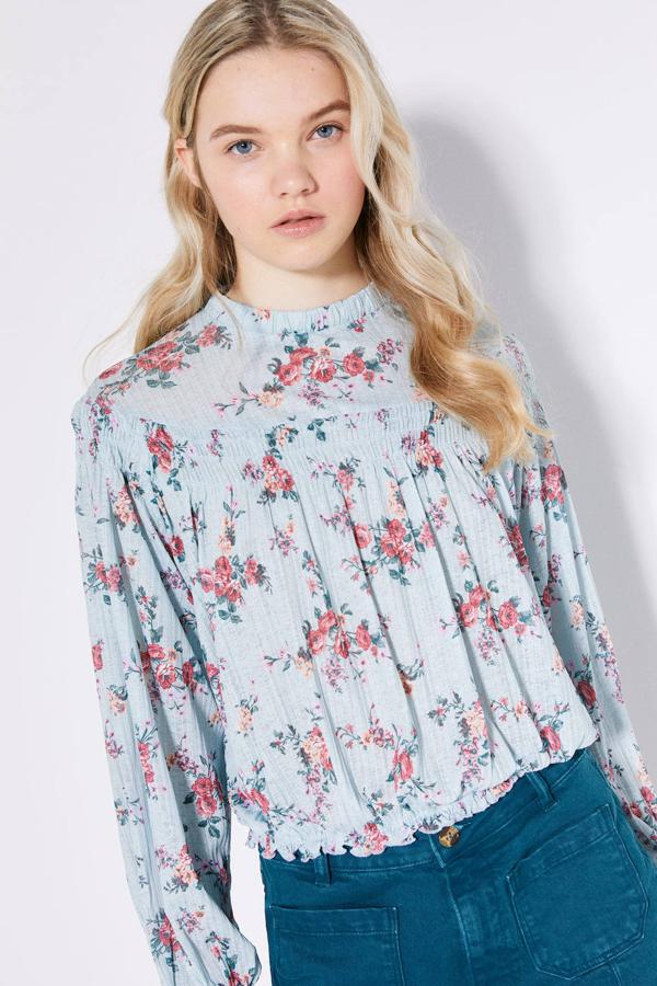 Blusa de tejido fluido con manga larga, cuello redondo, detalles fruncidos, terminaciones elásticas y floral print, en celeste. Tiene un coste rebajado de 9,99 euros. Cómpralo aquí