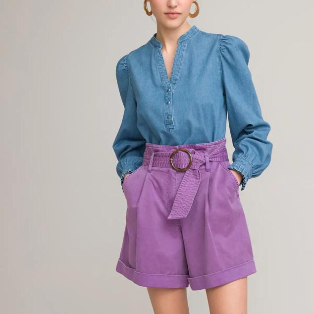 Recupera la camisa vaquera tradicional y dibuja un look más moderno y femenino. Tiene un cuello Mao, volantes en los puños y frunces en los hombros. Combina a la perfección con una prenda de abajo colorida. Es de La Redoute. Precio: 44,99 €.