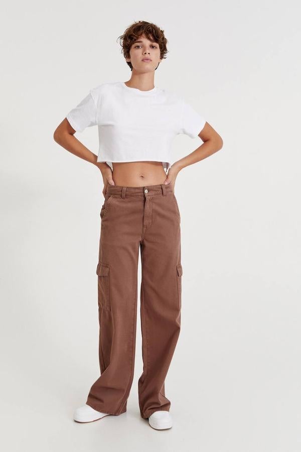 Pantalón cargo con tiro medio, pernera extra larga y amplia, seis bolsillos y trabillas para el cinturón, de Pull&Bear. Cómpralo en tres colores diferentes por 5,99 euros.