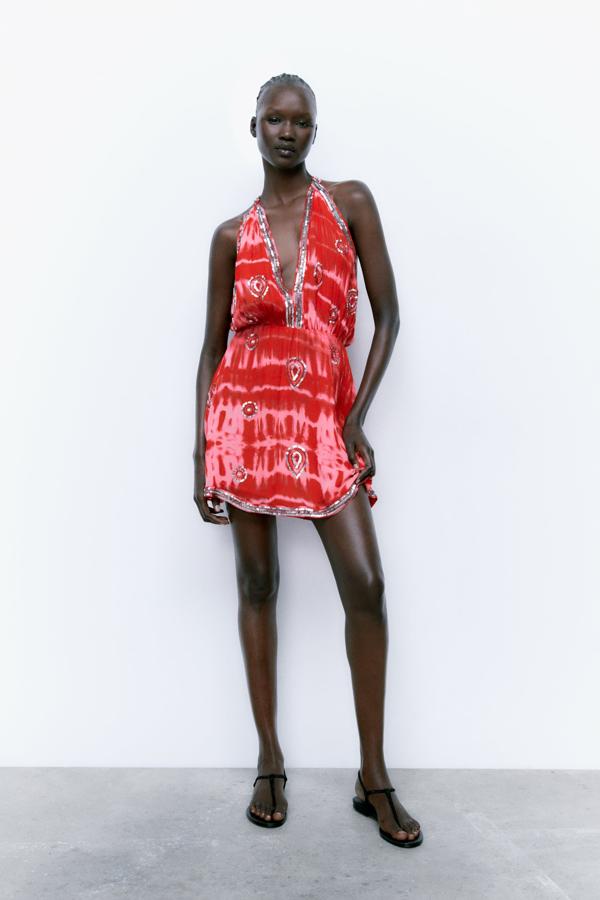 Vestido corto de escote pico y tirantes anchos con detalles de lentejuelas plateadas. Es de Zara. Precio: 59,95 €.