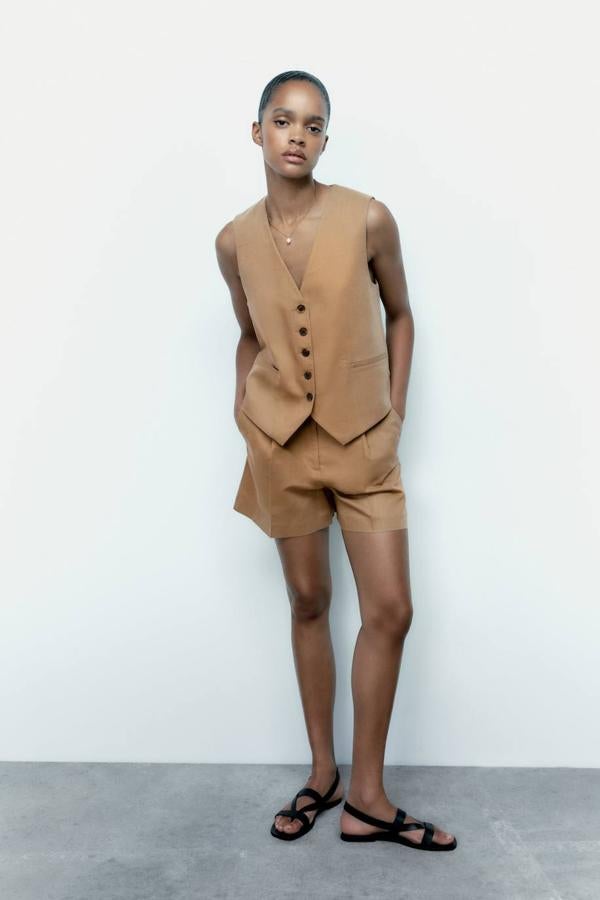 Traje de lino compuesto por chaleco entallado con escote de pico y bolsillos de ojal, más bermudas de vestir con talle alto y detalles de pinzas, en tono khaki, de Zara. Ambas piezas cuestan 25,95 euros, cada una.