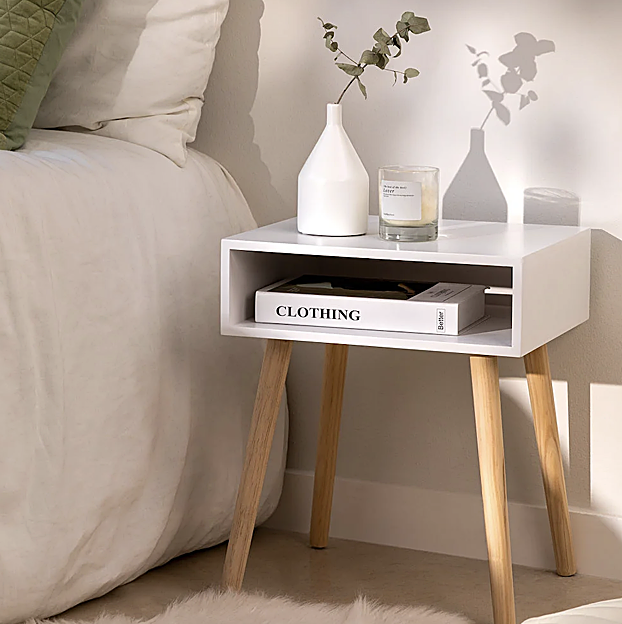 Una mesita de noche en color blanco y de madera para un dormitorio atemporal y moderno.