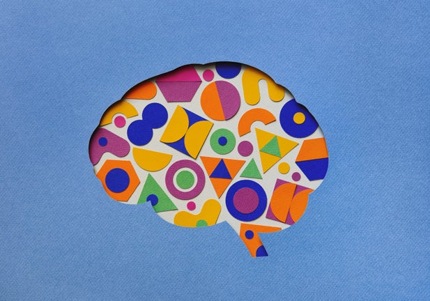 Paper craft illustration of brain filled with multi colored geometric shapes. Creative mind